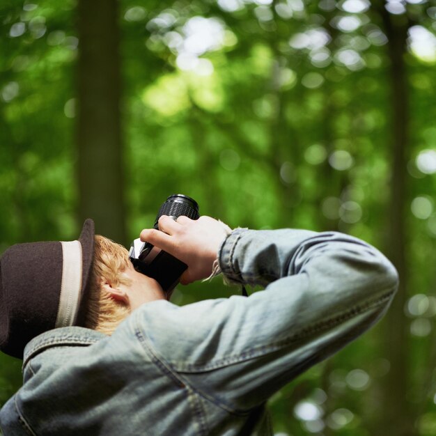 Fotografare la natura e l'uomo con una fotocamera viaggio e turismo con una vista alberi e libertà persona fotografia e ragazzo con montagne viaggiatore e retrò con paesaggio creativo e avventura