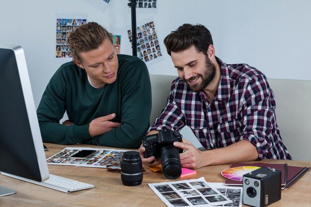 Fotografi che esaminano le foto catturate con la fotocamera digitale