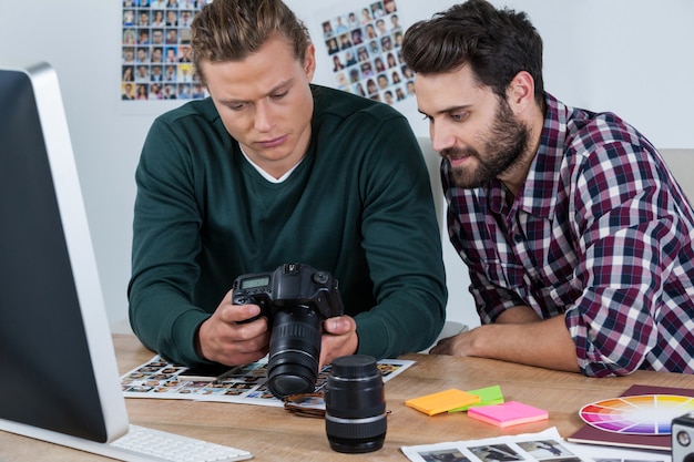 Fotografi che esaminano le foto catturate con la fotocamera digitale