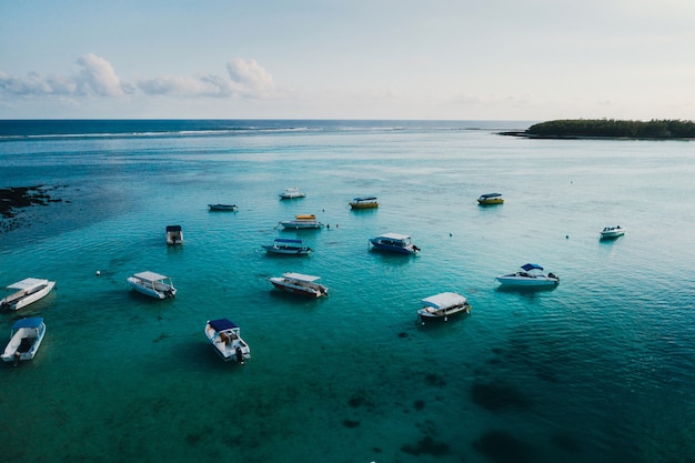 Fotografia aerea della costa orientale dell'isola di Mauritius. Bellissima laguna dell'isola di Mauritius ripresa dall'alto. Barca a vela in laguna turchese.