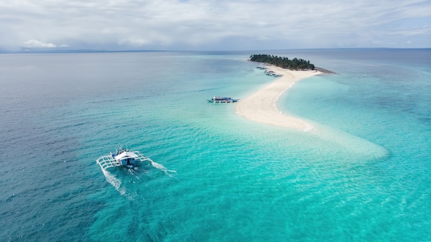 Fotografia aerea di una tipica nave filippina che arriva in un paradiso tropicale dell'isola