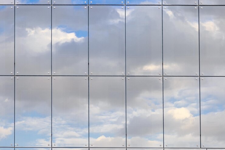 Foto fotografia completa di un moderno edificio in vetro con il riflesso delle nuvole