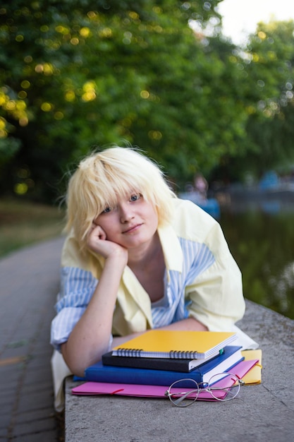 Fotografia con ragazza adolescente con libri e orientamento verticale delle cartelle degli studenti