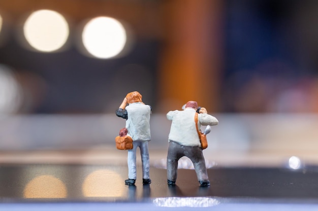 Fotografia di persone in miniatura che tiene una macchina fotografica e copia lo spazio per il testo