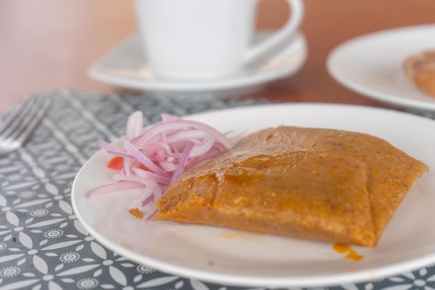 Fotografia di tamales con salsa creola nella mesa di un ristorante nel desayuno.