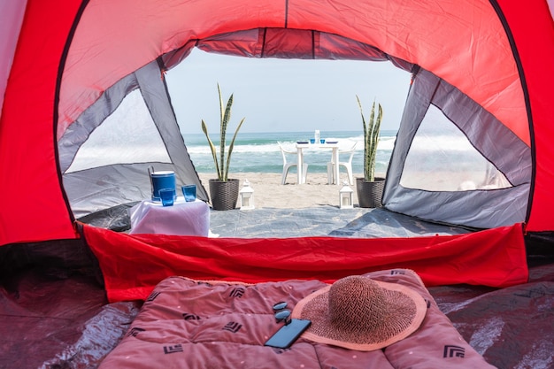 Fotografia di una tenda da campeggio rossa sulla spiaggia in spiaggia di Yuri Ugarte Cespedes