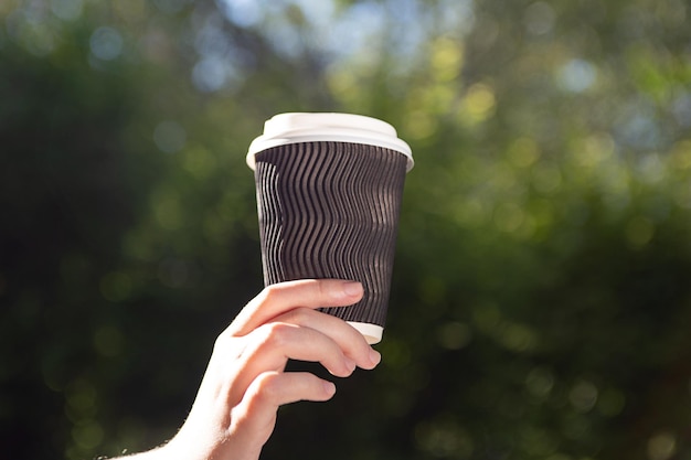 Fotografia in primo piano della donna che tiene una tazza di caffè nella manoPlace per il logo