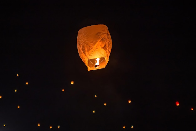 Fotografia notturna di una lanterna dei desideri che vola nel cielo.