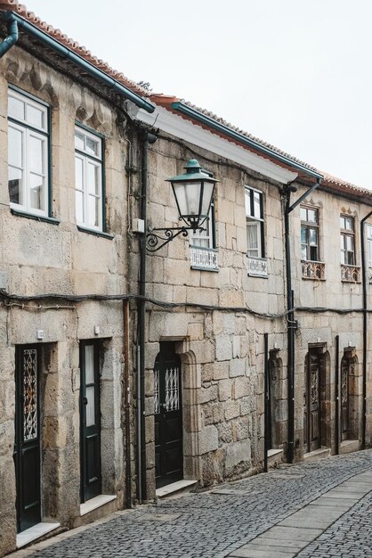 Fotografia verticale di una strada con antichi edifici in pietra in Portogallo