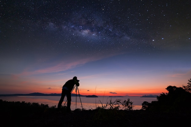 Fotografo che fa alba di fotografia con la galassia della Via Lattea.