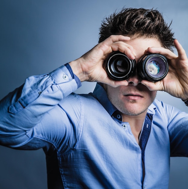 Fotografo che guarda attraverso le lenti in studio