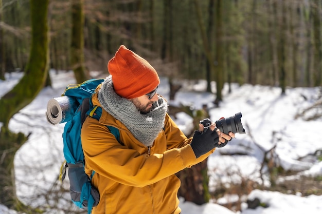 Fotografo che scatta una foto in inverno sulla montagna con gli hobby invernali della neve