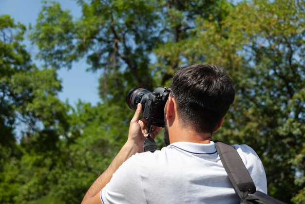 Fotografo che tiene la macchina fotografica in natura