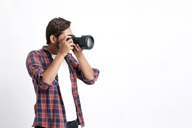 Fotografo con fotocamera sul muro bianco