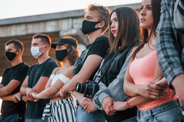 Fotografo con macchina fotografica Gruppo di giovani in protesta che stanno insieme Attivista per i diritti umani o contro il governo