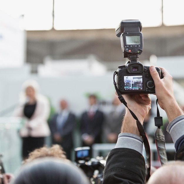 Fotografo con macchina fotografica in conferenza