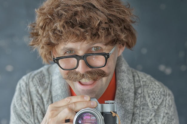 fotografo con una fotocamera analogica vintage, un uomo con i baffi, immagini divertenti per l'apprendimento della fotografia