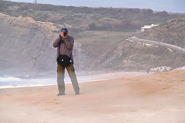 Fotografo con una macchina fotografica sulla spiaggia