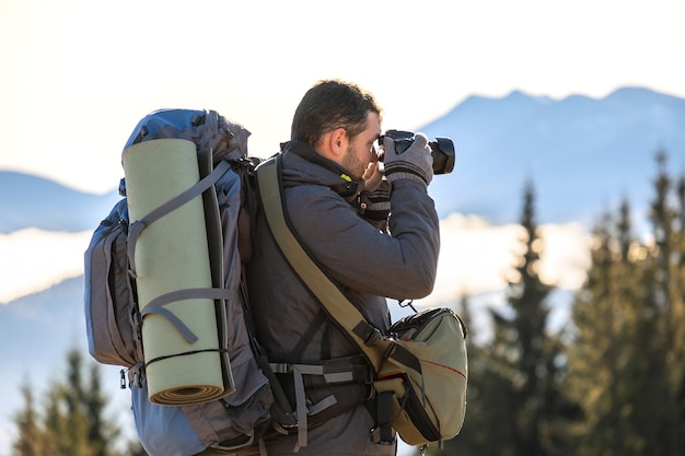 Fotografo con zaino da trekking per scattare foto della natura con la fotocamera digitale.