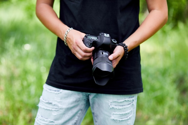 Fotografo dell'uomo con una macchina fotografica in mano all'aperto