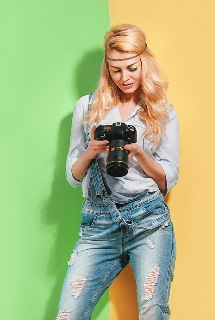 Fotografo della donna che fa i colpi su una superficie di colore luminosa un giorno soleggiato