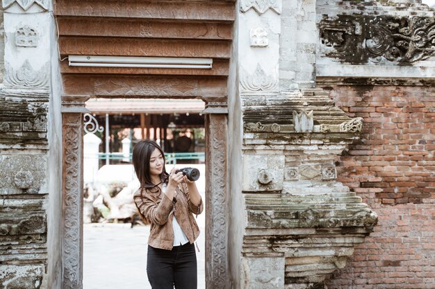 Fotografo della donna che prende immagine facendo uso della macchina fotografica