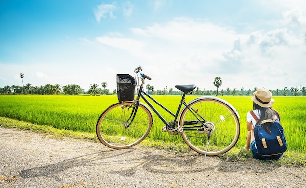 fotografo donna seduta vicino alla bicicletta e scattare foto per la visualizzazione del campo di riso di fotocamera