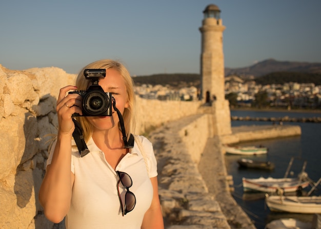 Fotografo donna viaggiatore con fotocamera professionale