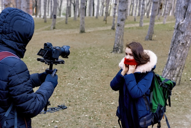 Fotografo e donna nella foresta di fine inverno