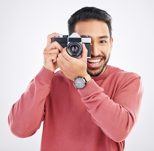 Fotografo felice e ritratto di un uomo asiatico con una macchina fotografica isolata su uno sfondo bianco in studio Lavoro di sorriso e un giornalista giapponese in fotografia che scatta foto per i media o i paparazzi