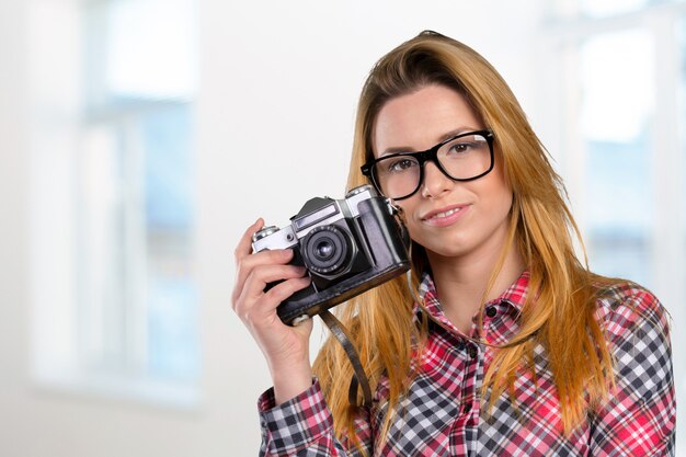 Fotografo femminile che tiene una macchina fotografica d'annata