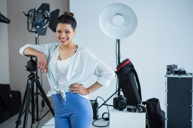 Fotografo femminile felice che sta nello studio