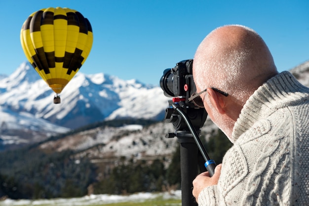 Fotografo in cima alla montagna con l'aerostato di aria calda