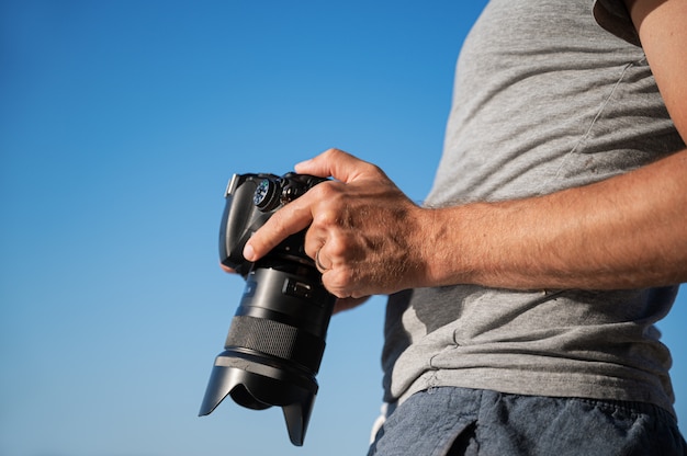 Fotografo maschio che controlla la sua macchina fotografica