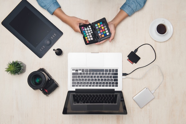 Fotografo maschio che lavora con tablet alla scrivania.