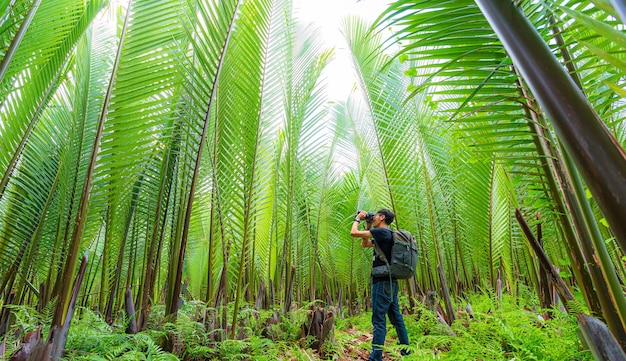Fotografo maschio che scatta foto nel fotografo di viaggio forestnature nella giungla tropicale