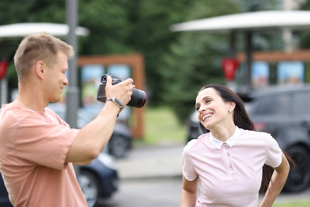 Fotografo maschio con donna sorridente di fotografie della fotocamera