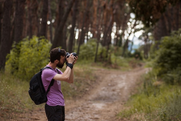 fotografo naturalista. uomo con la macchina fotografica nella foresta. voglia di viaggiare e stile di vita di viaggio