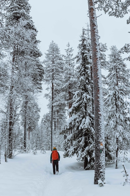 Fotografo paesaggista che fa trekking in una Lapponia innevata, Finlandia