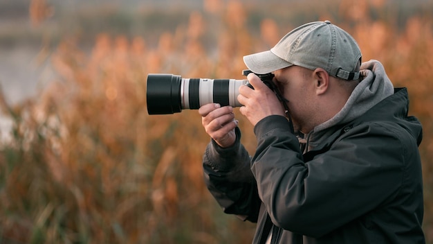 Fotografo professionista della fauna selvatica che scatta foto con attrezzatura fotografica digitale di uccelli e animali in natura