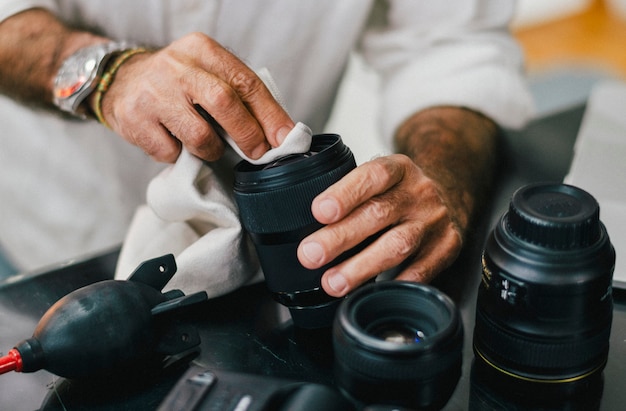 Fotografo senior che pulisce il suo obiettivo