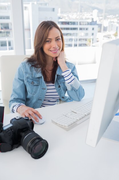 Fotografo sorridente che modifica allo scrittorio