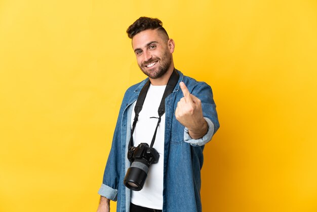 Fotografo uomo isolato su sfondo giallo che fa il gesto imminente