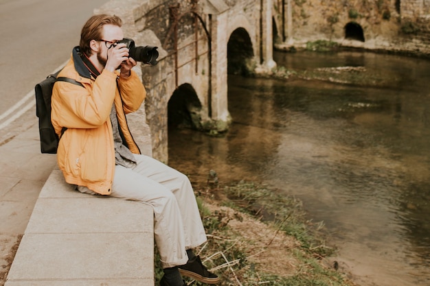 Fotografo uomo scattare foto nel villaggio in Cotswolds, UK