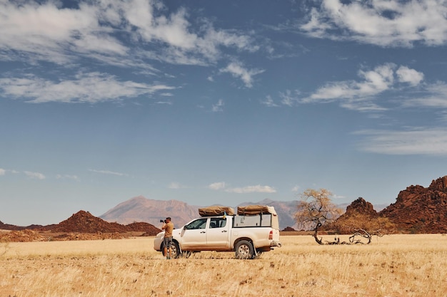 Fotografo vicino all'auto che si trova nei deserti dell'Africa Namibia