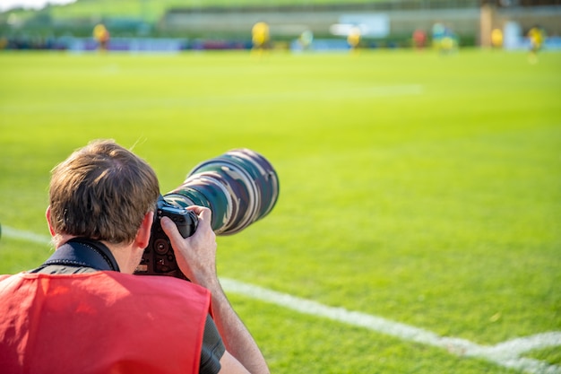 Fotoreporter con teleobiettivo su una partita di calcio