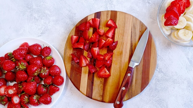 Fragola affettata su tavola di legno Preparazione di frullato o frullato con fragola e banana