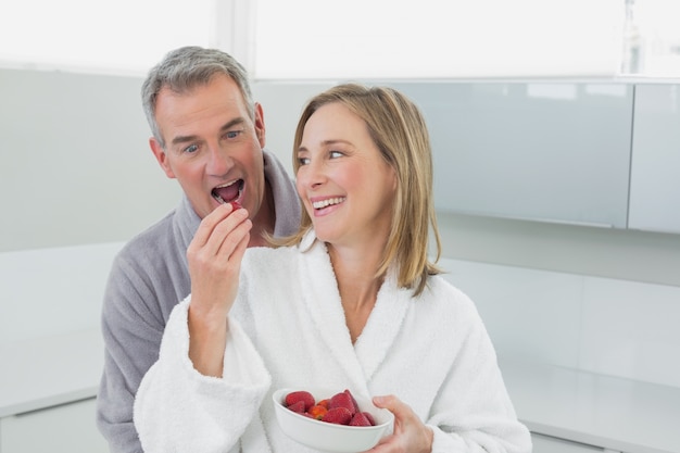 Fragola d&#39;alimentazione dell&#39;uomo della donna felice in cucina