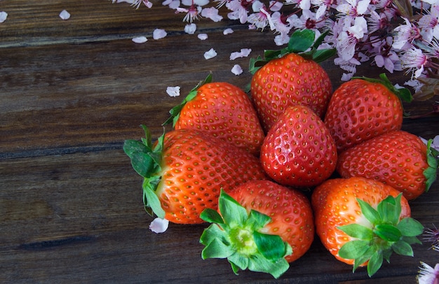 Fragola di Frash sulla tavola di legno con il fiore