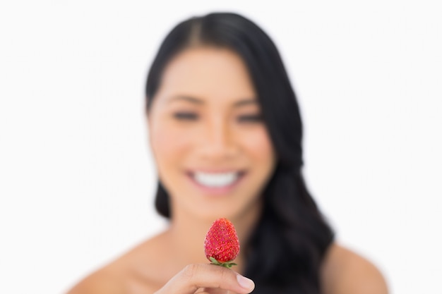 Fragola di modello dai capelli marrone attraente della tenuta